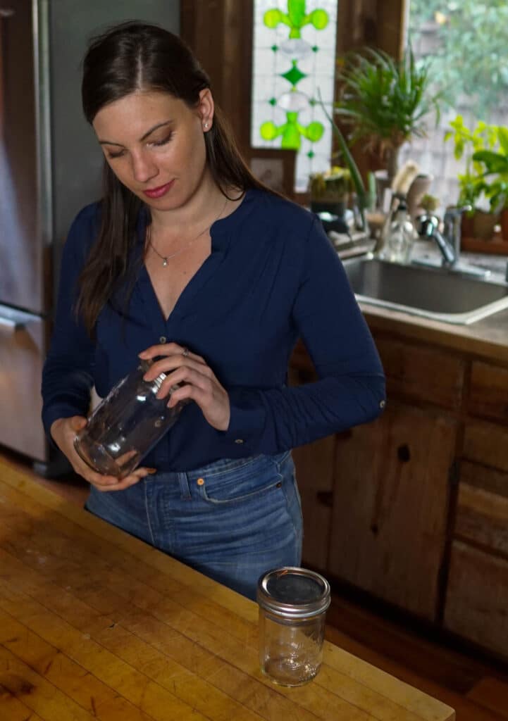 Woman screwing the lid onto glass food safe storage containers.