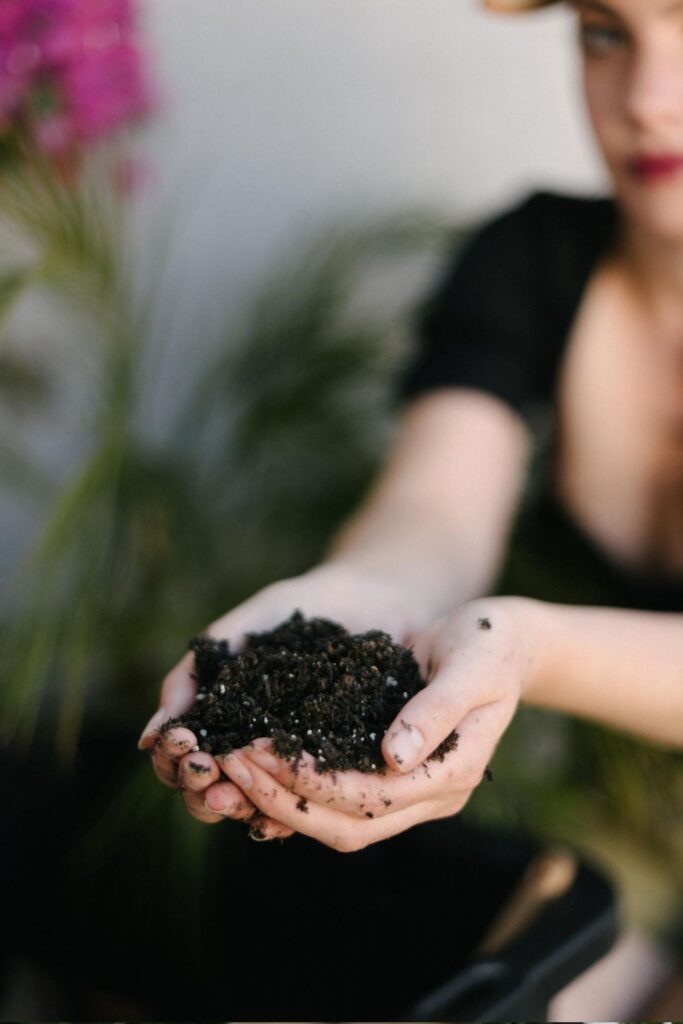 adding soil to compost bin