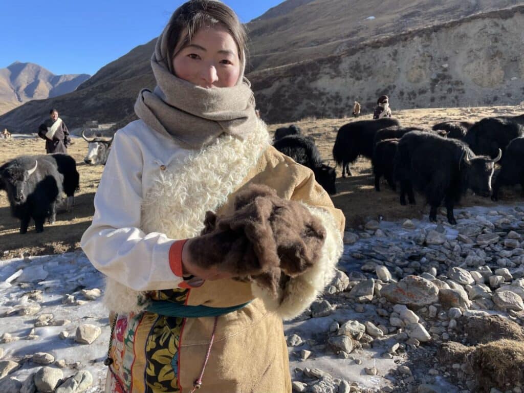a woman out in the mountains holding Shokay wool