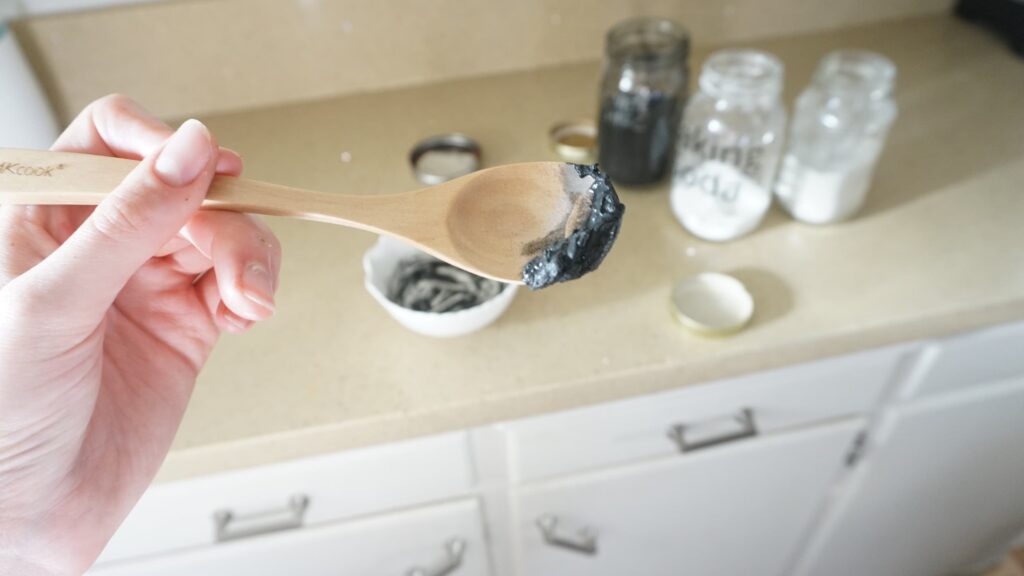 Hand holding a spoonful of DIY blackhead remover mixture