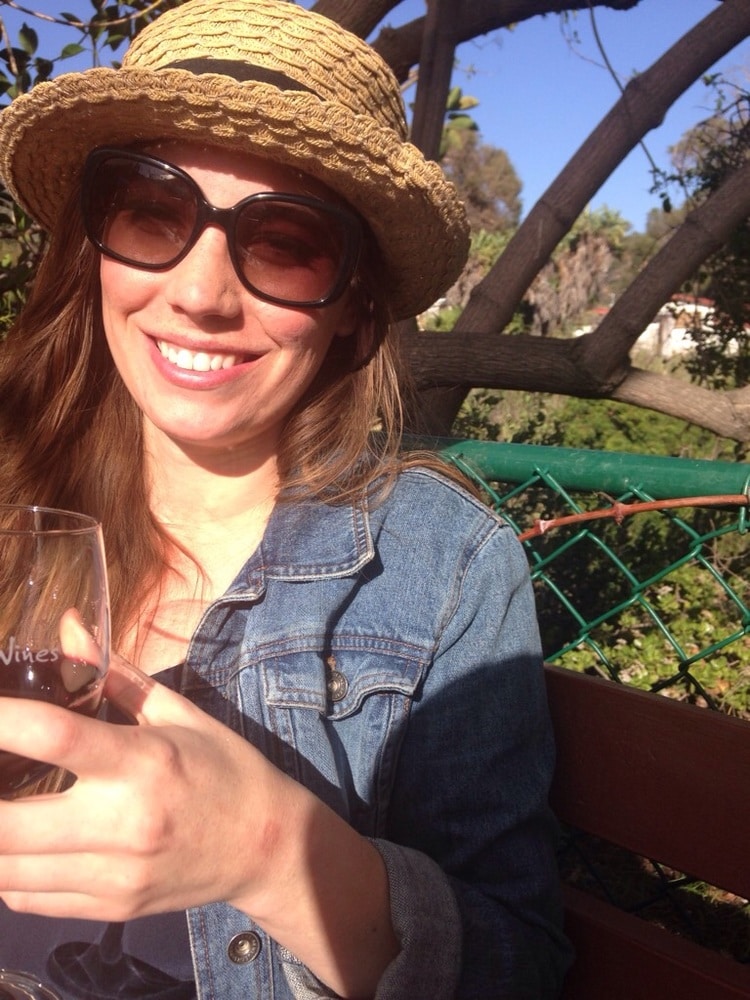 woman wearing a sunhat and sunglasses as part of her travel essentials for women.