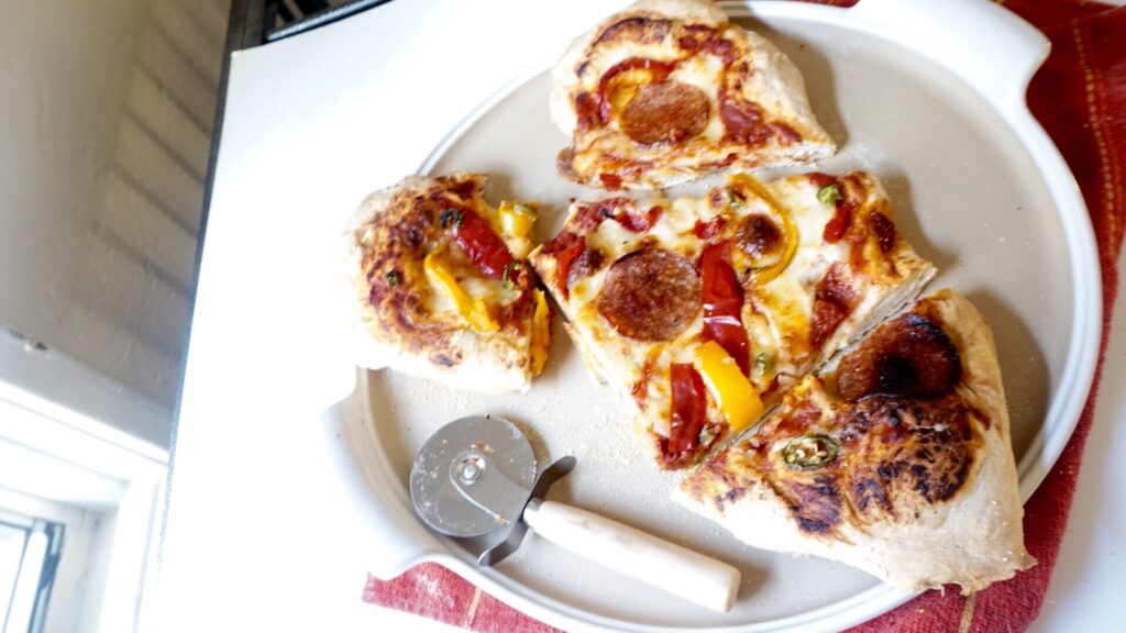 homemade pizza dough topped with marinara, mozzarella and a bunch of veggies as a serving idea for what to make with pizza dough