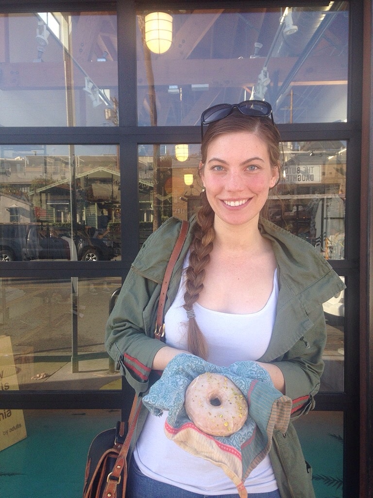 woman holding a reusable towel as a must have travel item instead of using napkins to hold her donut