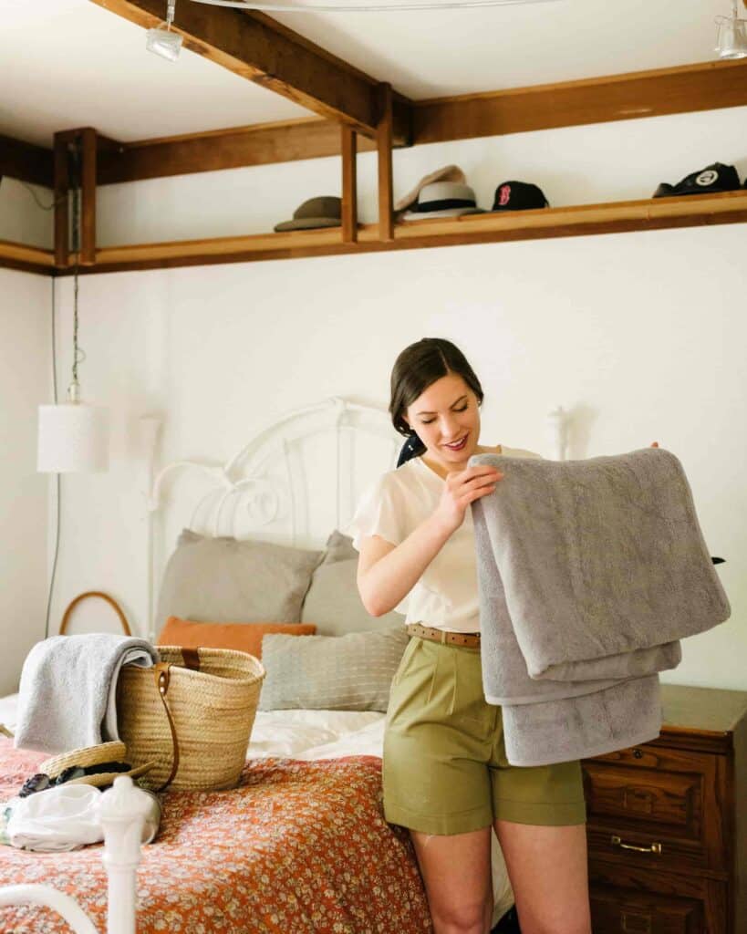 Woman packing a beach bag with her beach day essentials