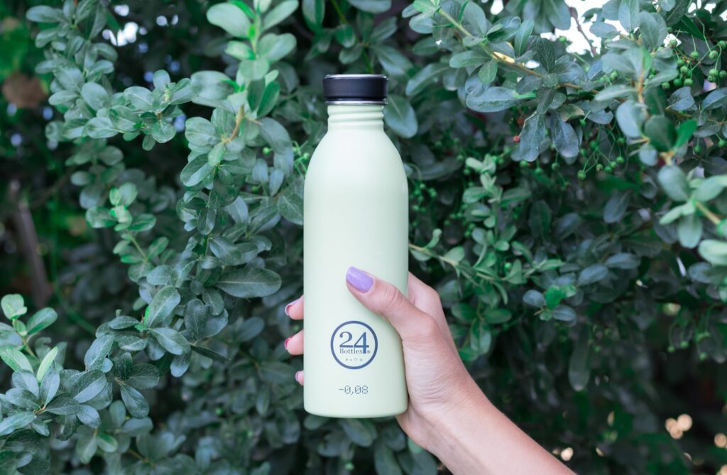 woman's hand holding a steel water bottle for plastic free living