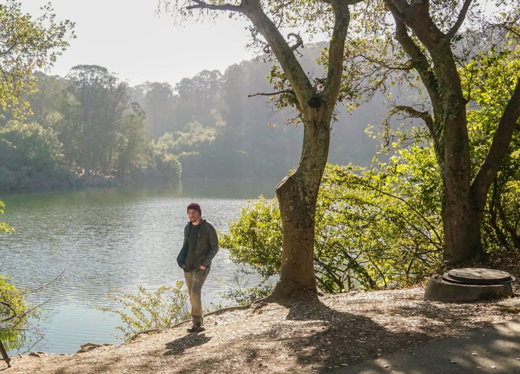 A man poses on a hike wearing his outdoor essentials.