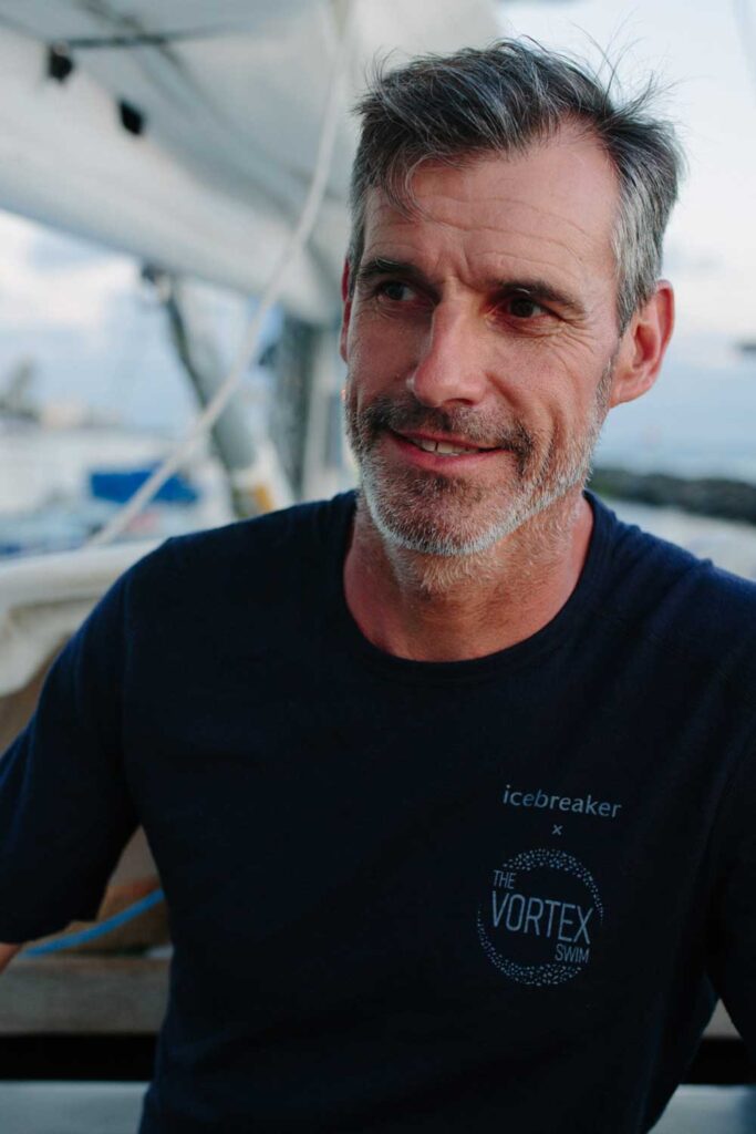 Man in "The Vortex Swim" shirt educating on how we can save the ocean and ocean pollution effects