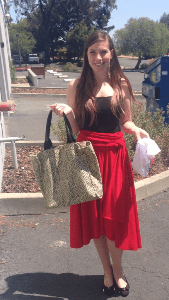 Woman in a parking lot holding totes to take to the grocery store for sustainable grocery shopping