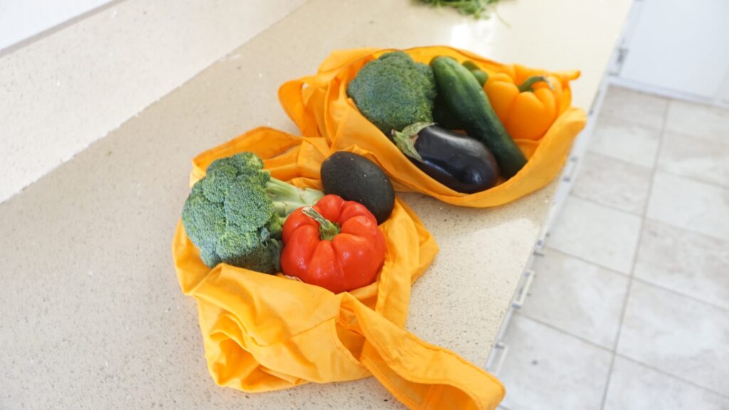 2 reusable tote bags full of produce