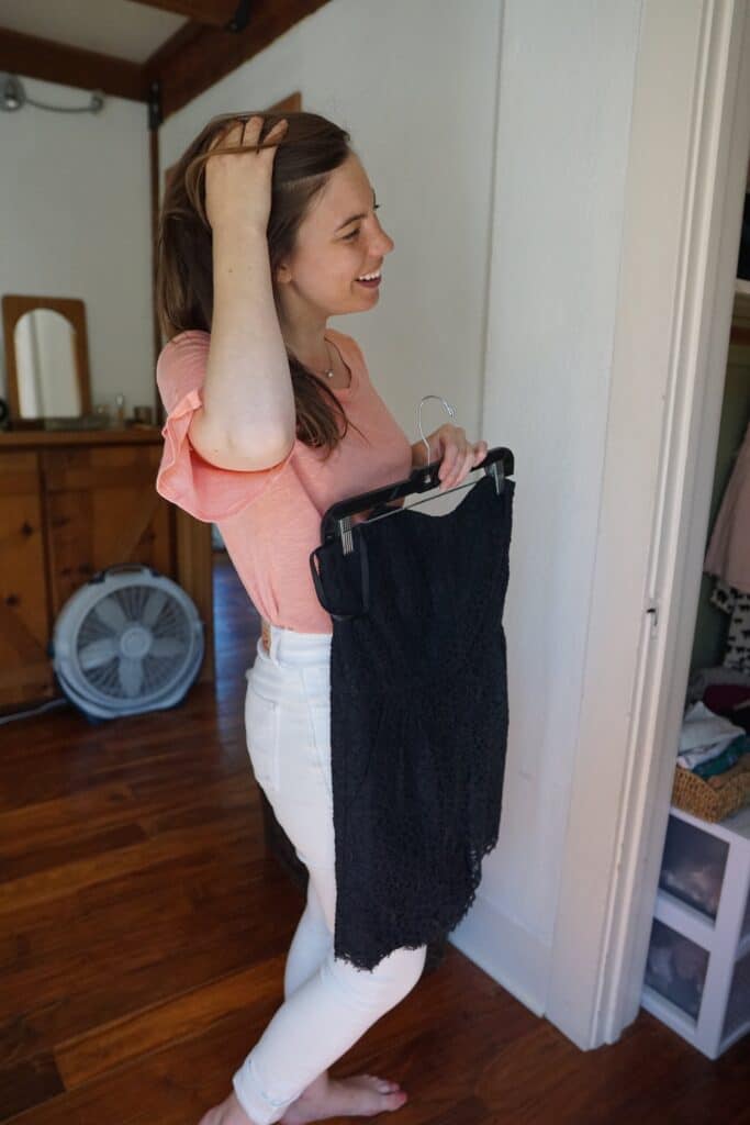 Woman holding up formal dress bought at one of the best second hand online stores.