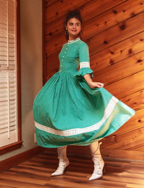 woman modeling a vintage dress and boots from one of the best thrift stores online