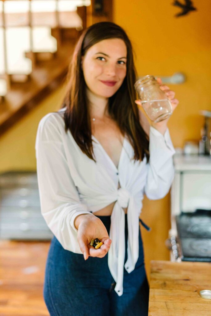 Woman holding a handful of the best supplement brands for adaptogens. 