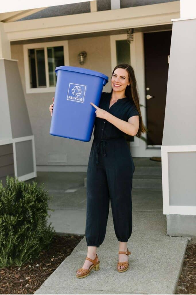 woman holding a recycle bin. 