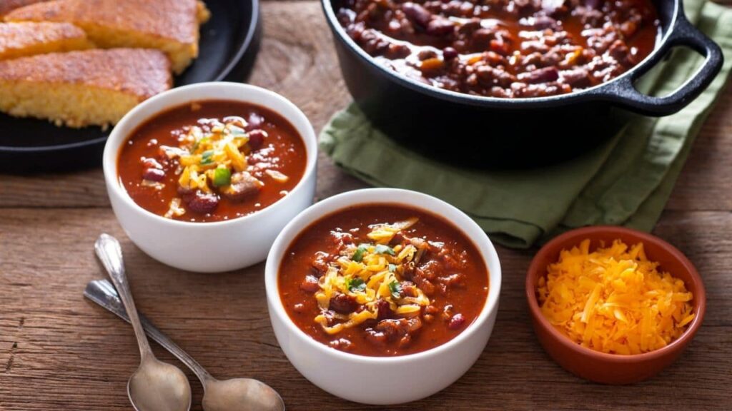 two white bowls of stovetop chili that can also be made in a Crockpot.