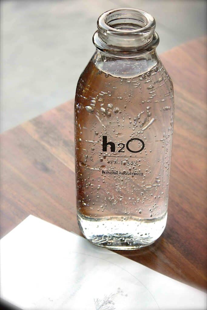 A glass water bottle filled with water as part of an eco friendly kitchen.