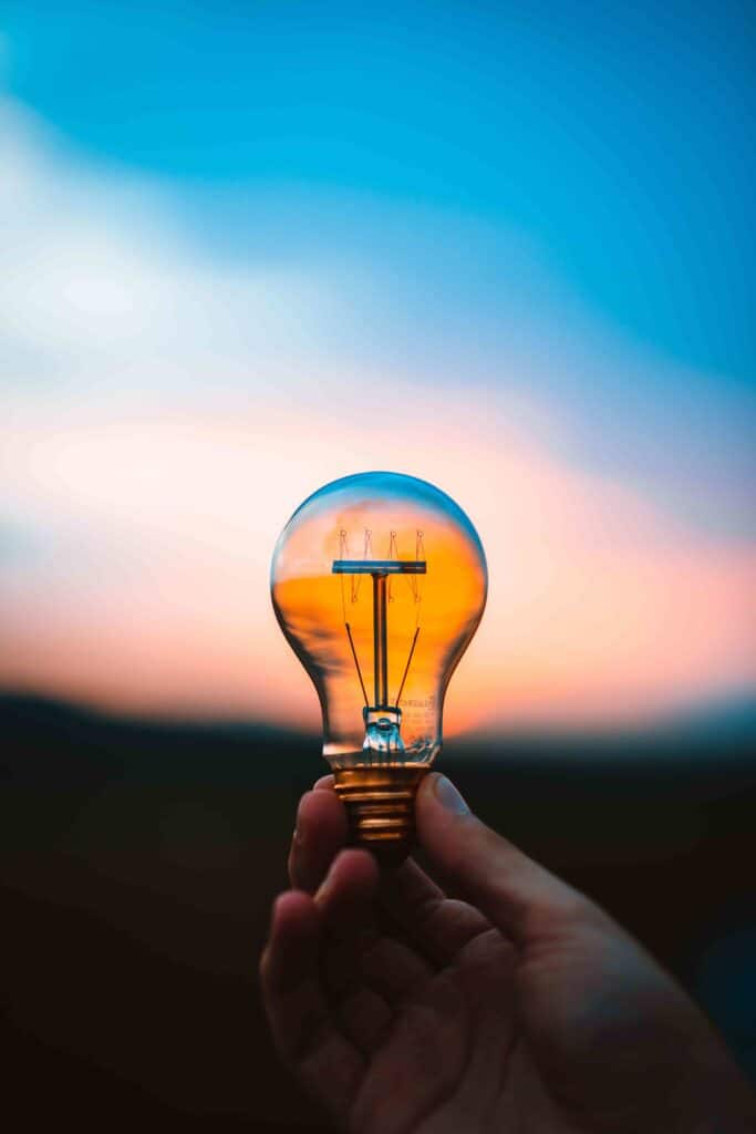 Close up of a hand holding an LED lightbulb, an eco friendly technology