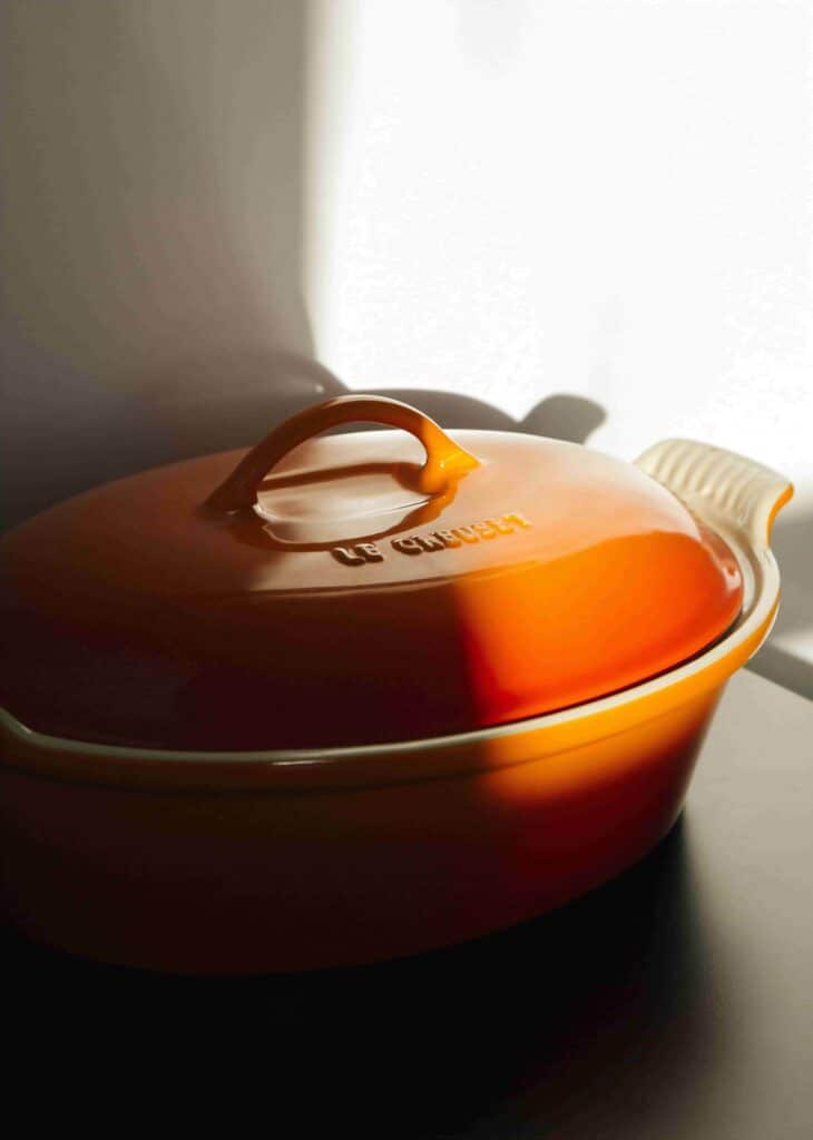 A photo of an orange Le Creuset Dutch oven - a staple for a sutainable kitchen