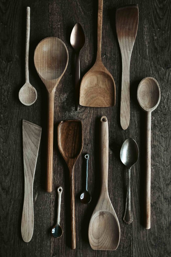 Top view of various wooden and metal kitchen utensils, spoons, and spatulas as part of a plastic free, sustainable kitchen.