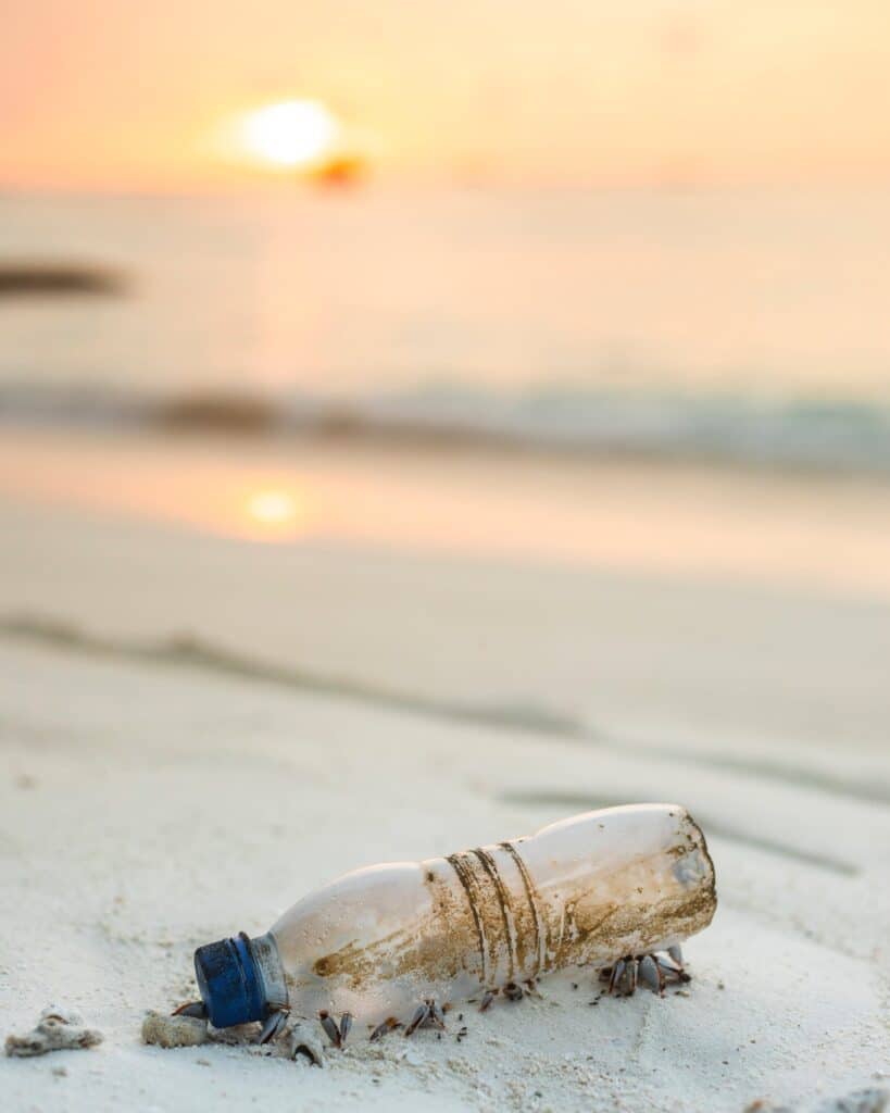 What are microplastics and where do they come from - a reusable plastic bottle on a beach.