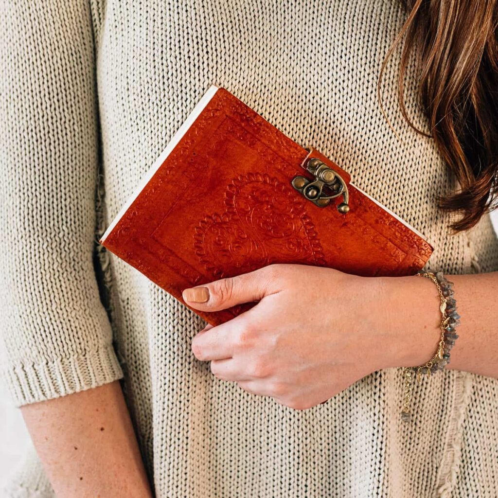 woman holding a red tree-free leather journal as an alternative valentines day gift.