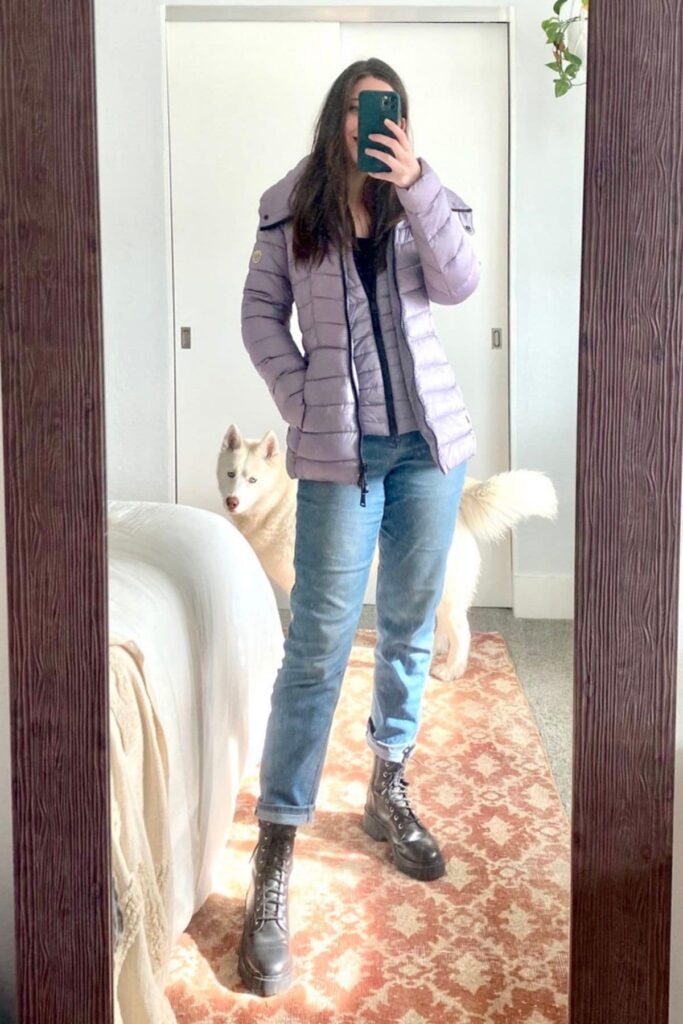 Woman wearing jeans, combat boots, and lavender bernardo coats.