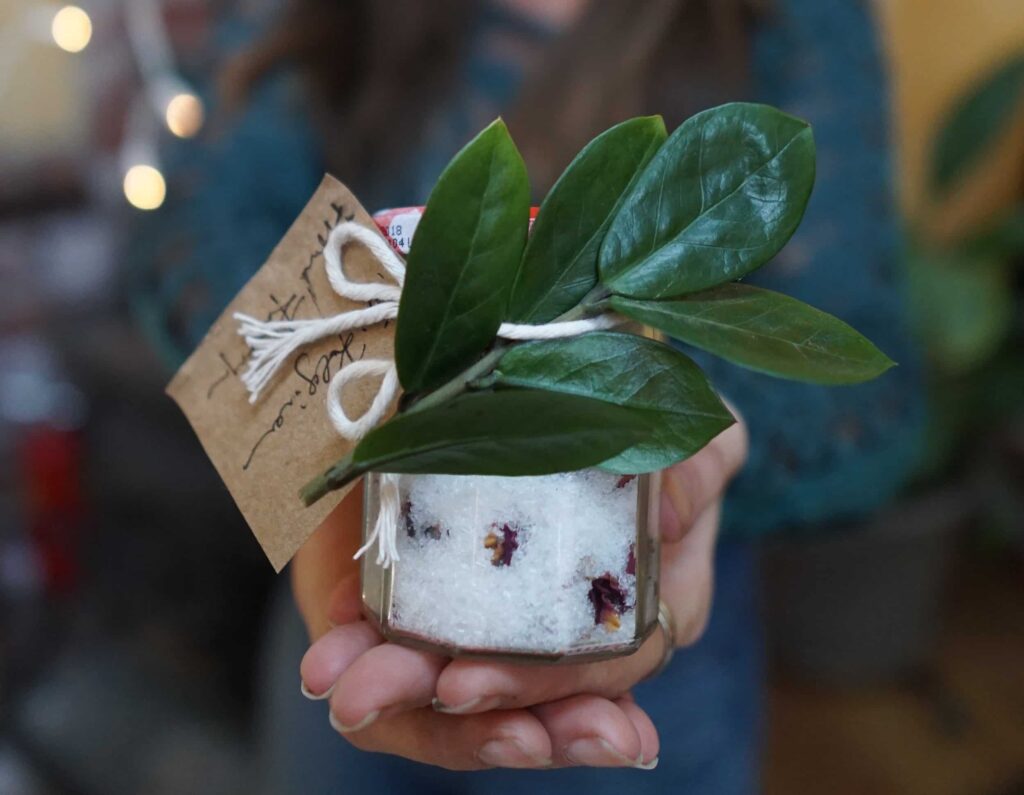 A woman's hands holding homemade bath salts for a sustainable Christmas gift.