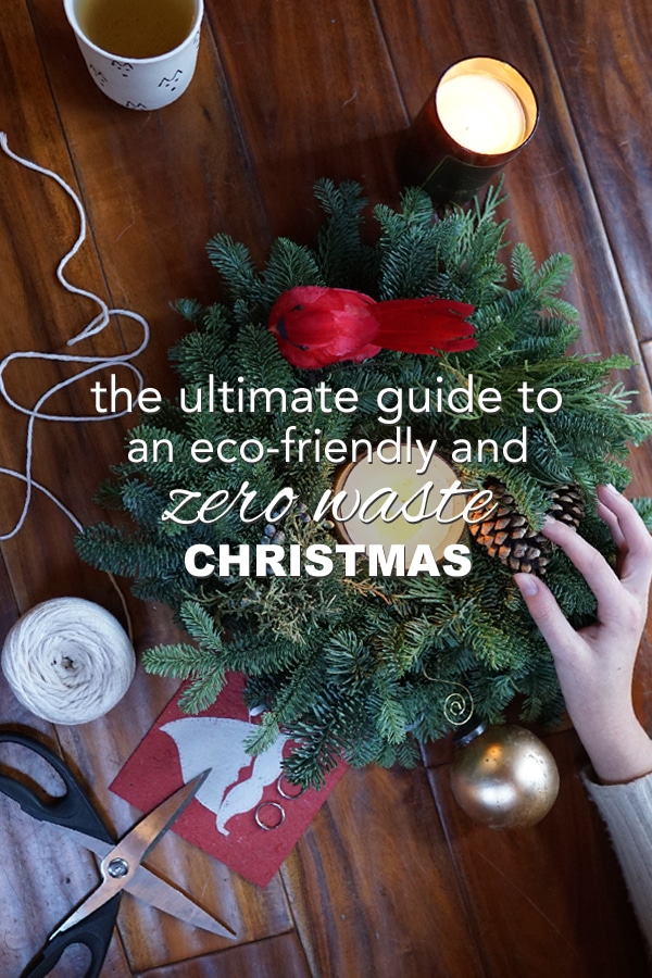 Top view of a table top wreathe with a candle in the middle, a cup of tea, and some yarn with overlay text reading "the ultimate guide to an eco-frinedly and zero waste Christmas"