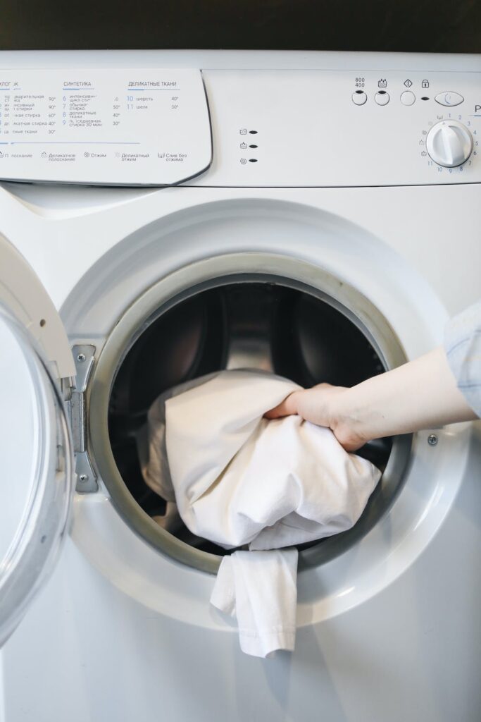 Laundry being put in a washing to be washed with clean laundry detergent.