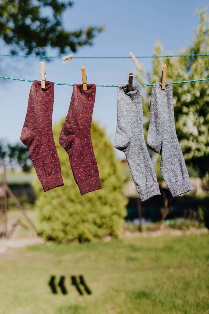 2 pairs of socks hang drying to illustrate a post about natural laundry detergent. 