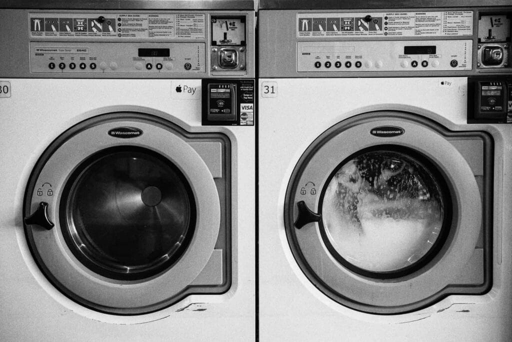 Two laundromat washing machines in black and white