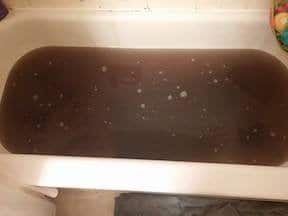 Tub full of almost-black water after stripping clothes of the residue from DIY laundry detergent 