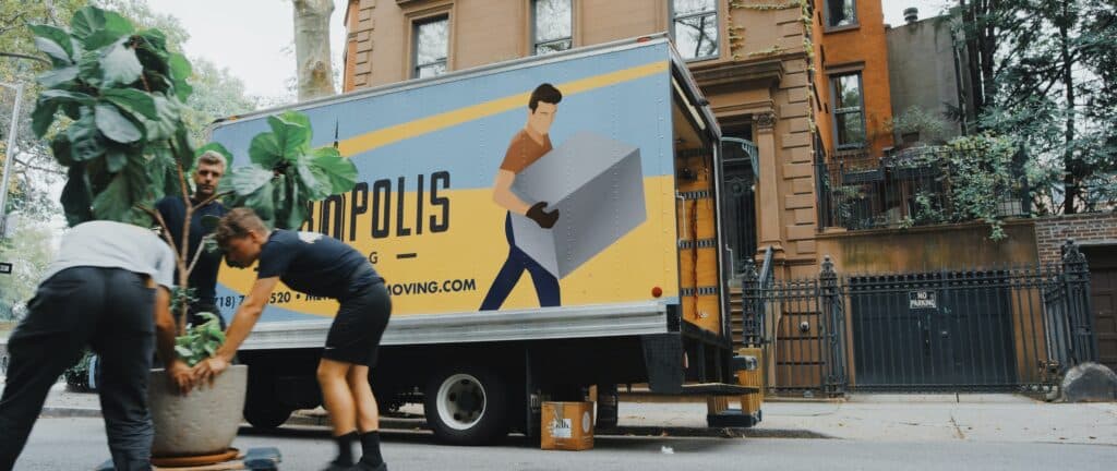 An Eco Movers truck outside of an apartment building.