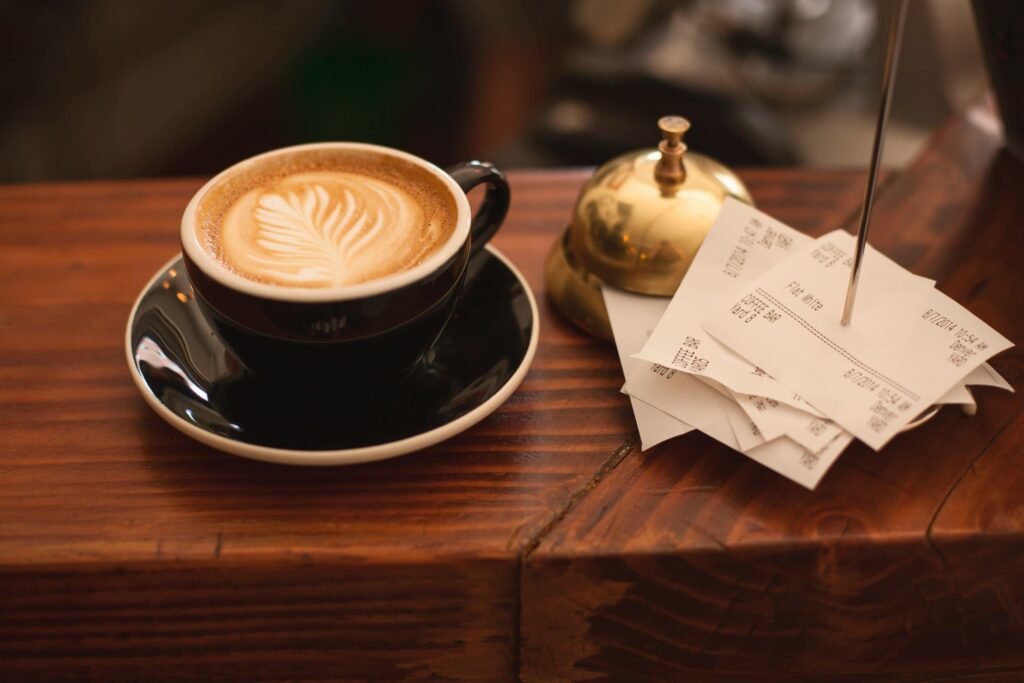 Latte cup with a stack of receipts to illustrate how to recycle paper receipts.