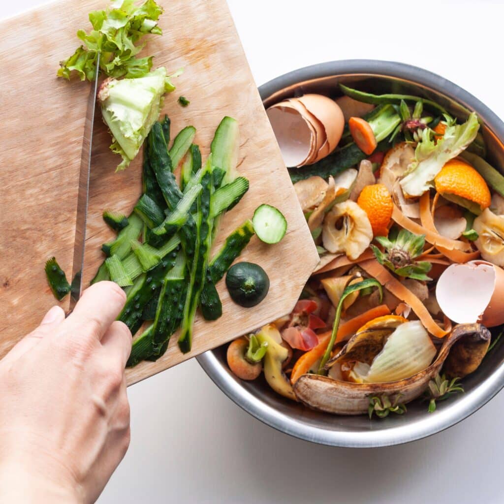 overhead image of food scraps being moved into a compost bin