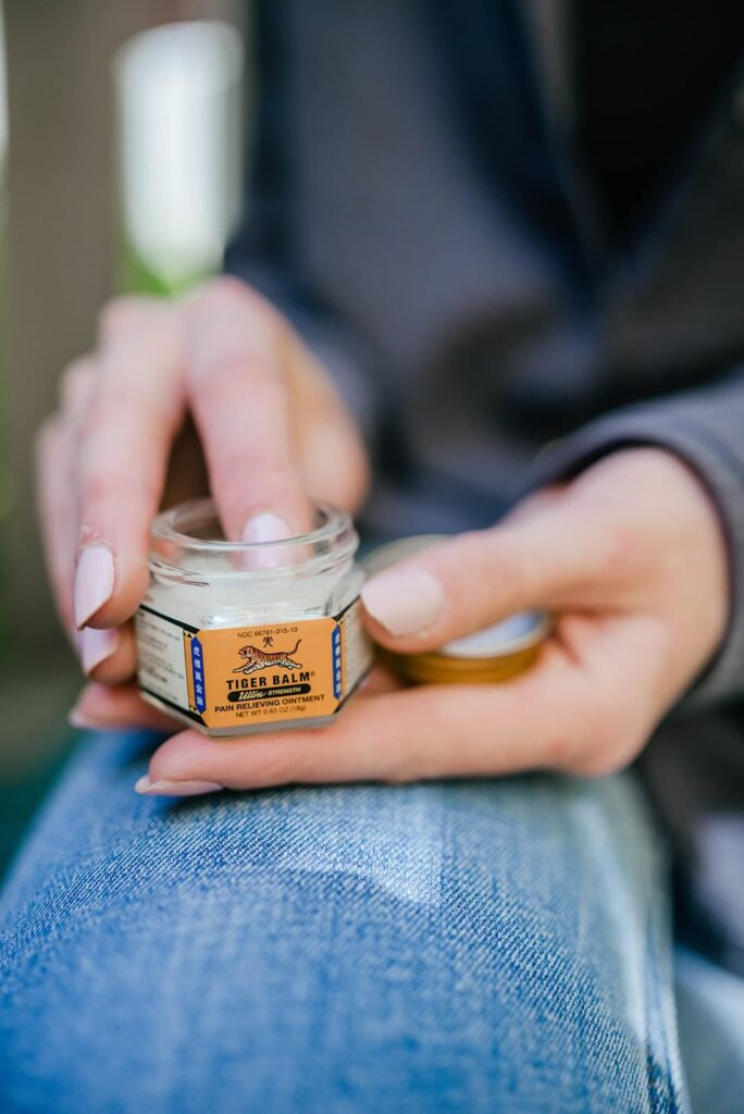 What is Tiger Balm? A woman scooping some Tiger Balm with her finger.