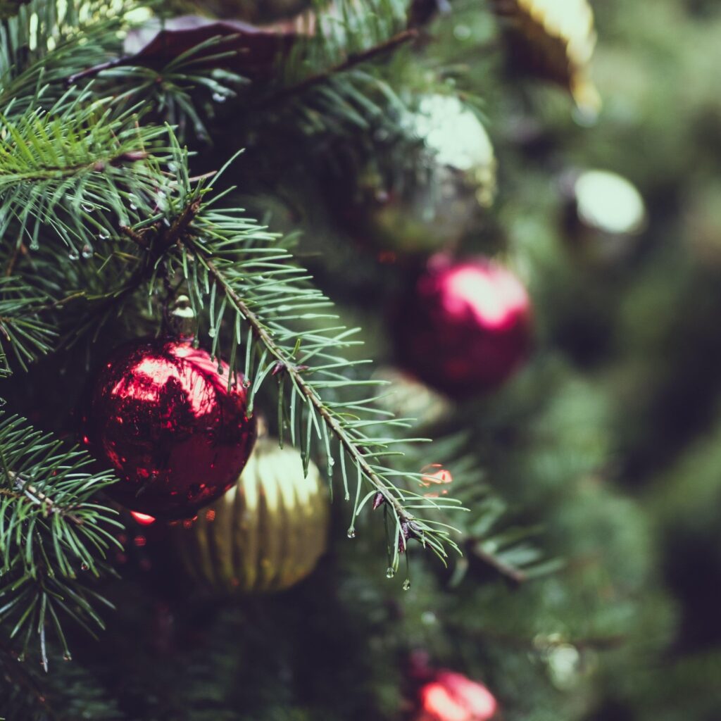 close up image of shiny ornaments hung on a Christmas tree
