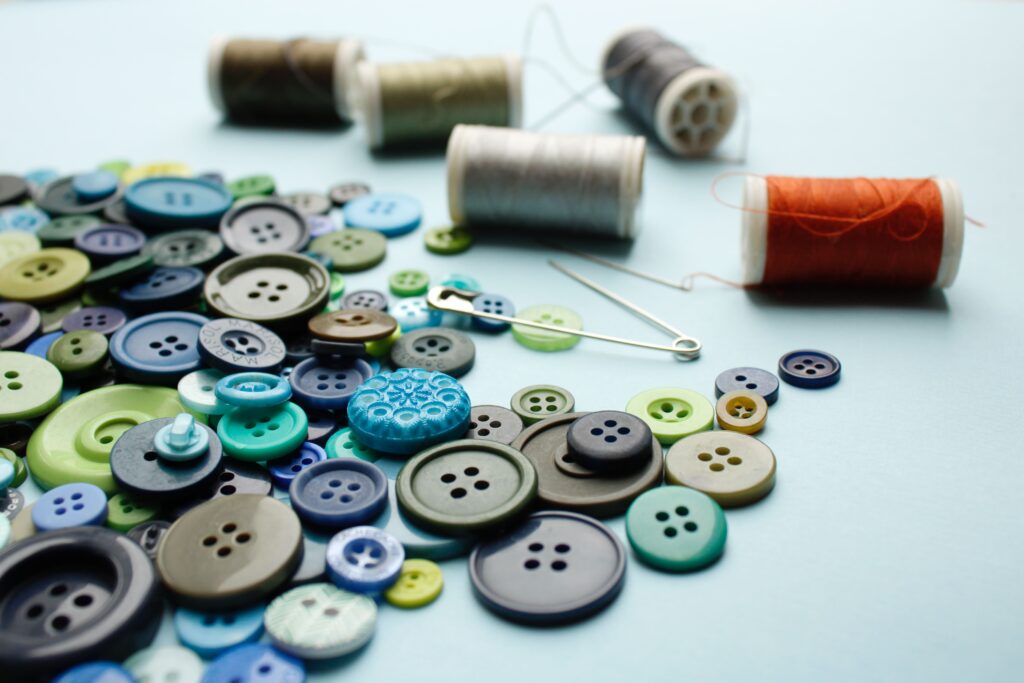 How do you repair a popped button? Loose buttons and spools and thread to illustrate fixing popped buttons