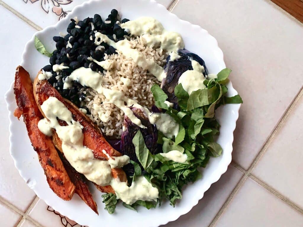 What I eat in a day as a vegan - top view of black beans, rice, roasted sweet potatoes and salad. 