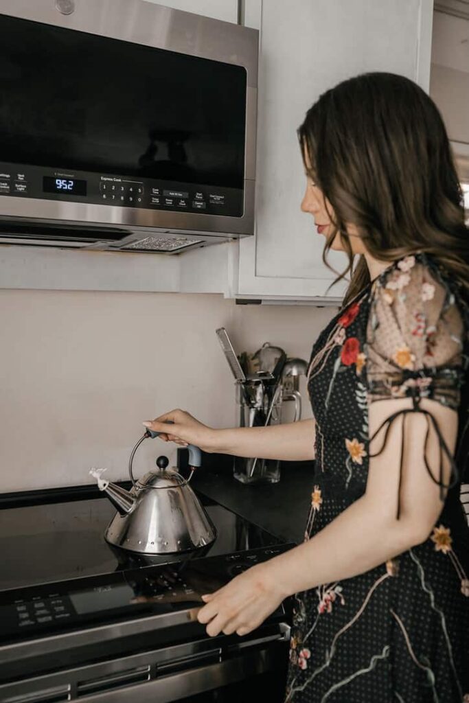 What is an induction cooktop? A woman heating up a tea kettle
