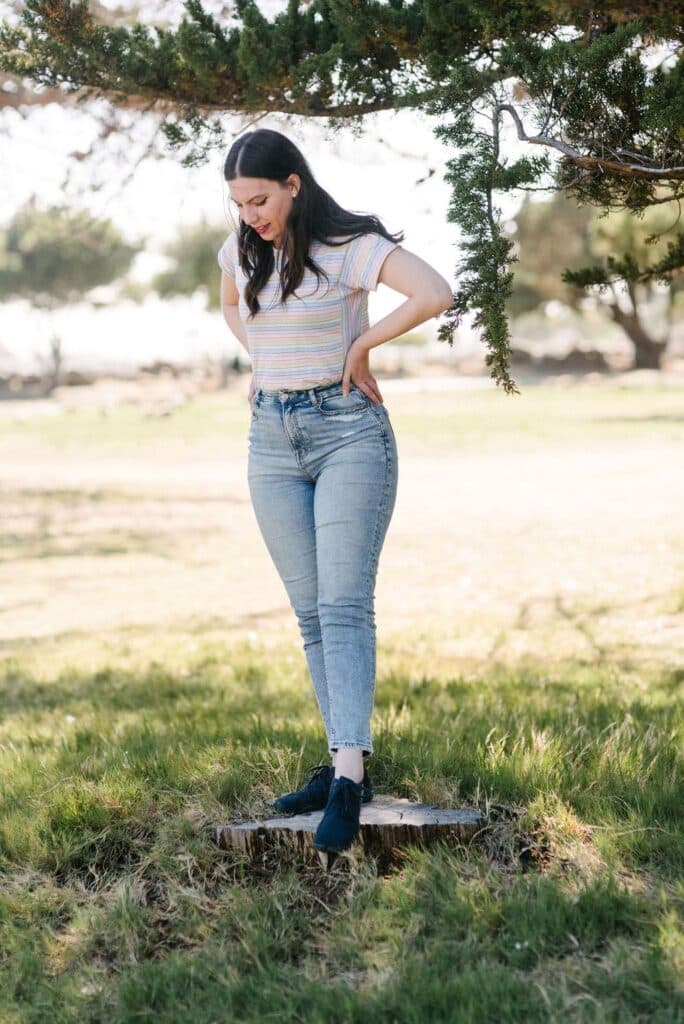 Kathryn from Going Zero Waste standing on a stump of wood while wearing Wildling Shoes.
