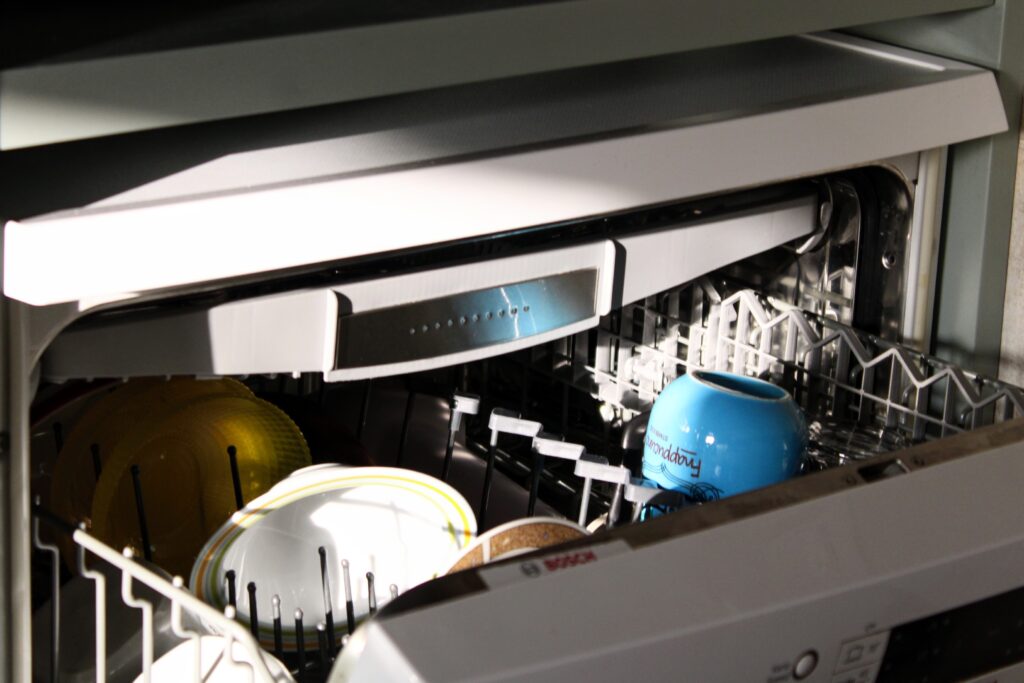 An image of an Energy Star dishwasher with dishes loaded into the top rack.