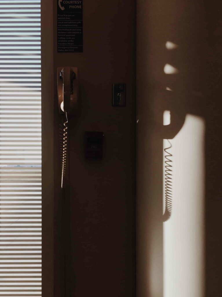 Call a friend: a phone hanging on a wall as a part of suggested self care day ideas. 