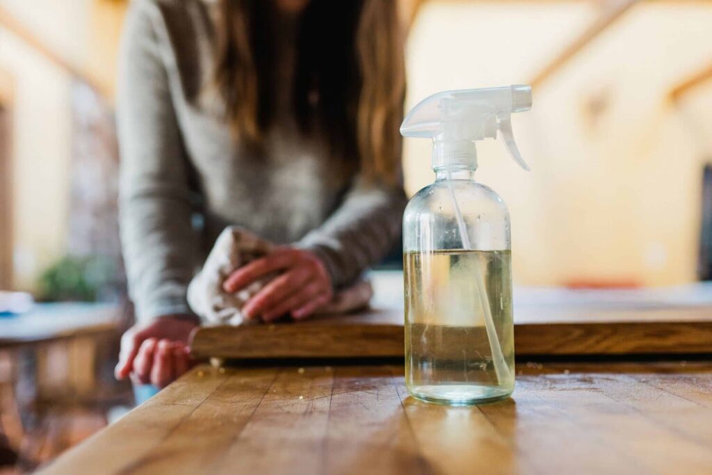 A woman cleaning her home with sustainable self care products. 