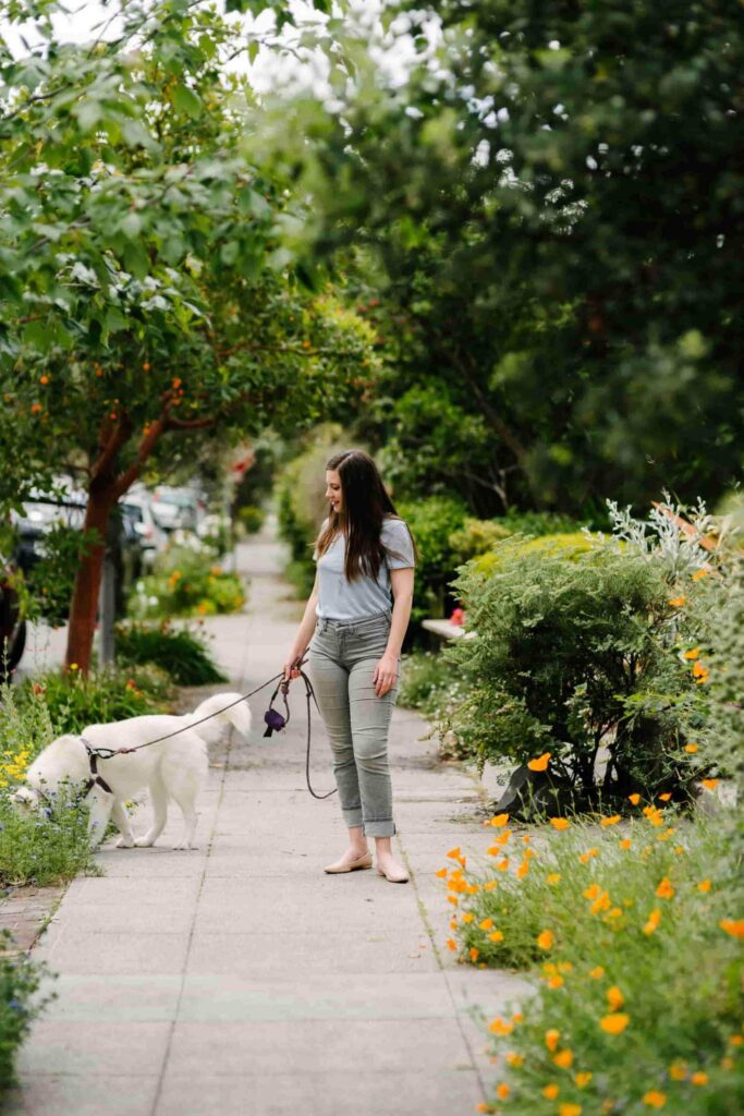 Sustainable self care: a woman taking her dog for a walk. 