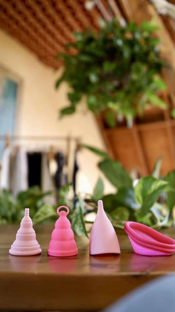 A line of pink menstrual cups on a table.