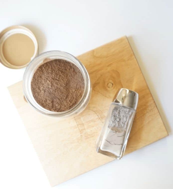 Homemade dry shampoo recipe in a large storage jar and a smaller shaker jar.